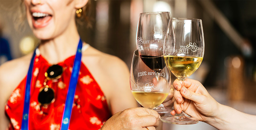 People toasting their wine glasses at Carnivus Maximus